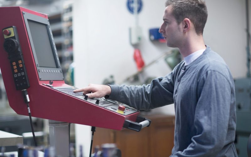 Young male technician using control panel in workshop
